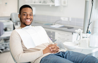Young black male sitting on a dental chair